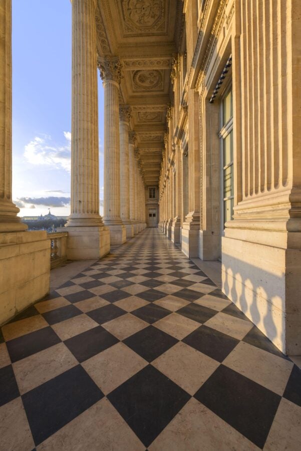 A grand marble loggia with tall neoclassical columns and a black-and-white checkered floor at Hôtel de la Marine in Paris, bathed in warm sunlight.
(Photograph by Jean-Pierre Delagarde, Centre des monuments nationaux.)