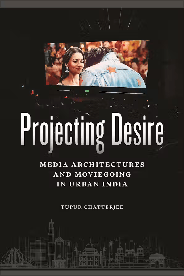 Black cover with a central image of a movie theater screen showing an Indian film scene of a man and woman embracing. The lower half features white silhouettes of Indian city architecture. Title text is in white, and the author, Tupur Chatterjee, is listed at the bottom.