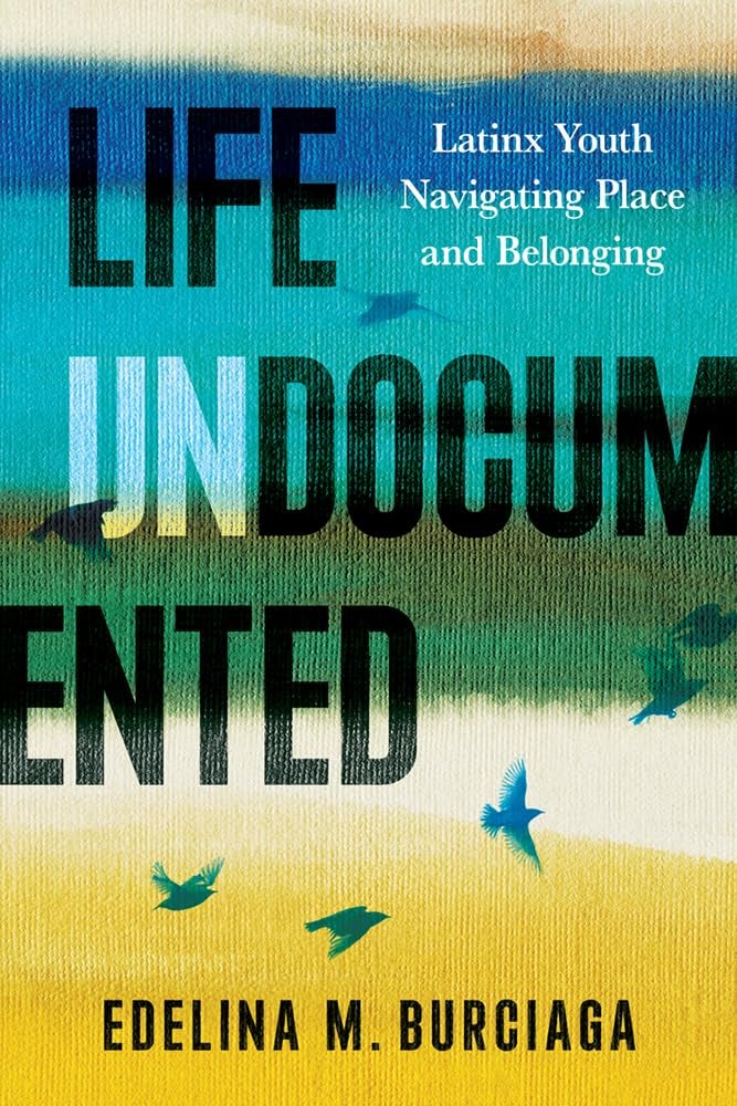 Book cover for Edelina M. Burciaga, “Life Undocumented: Latinx Youth Navigating Place and Belonging.” Abstract teal-gold bands with flying bird silhouettes; bold stacked title with “UN” emphasized.