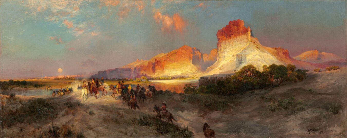 Riders on horseback pass glowing red and gold cliffs along Wyoming’s Green River at sunset.
