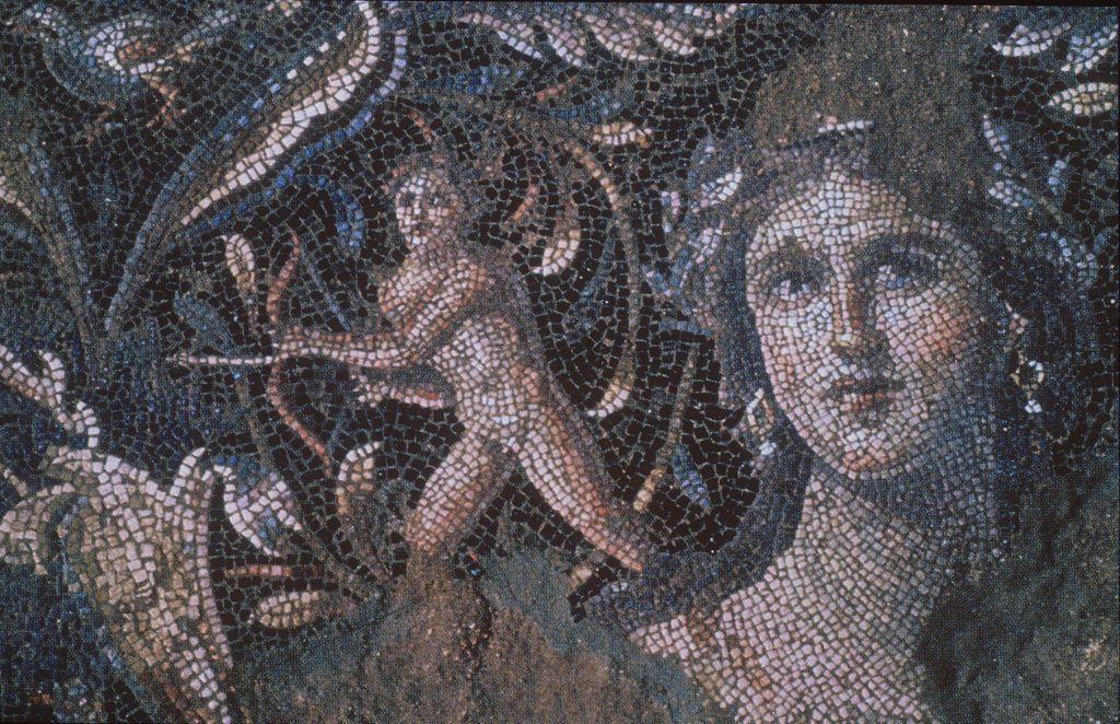 A Roman mosaic from 4th-century CE Sepphoris showing a detailed female face surrounded by foliage and a small nude male figure with a bow, rendered in colorful tesserae.