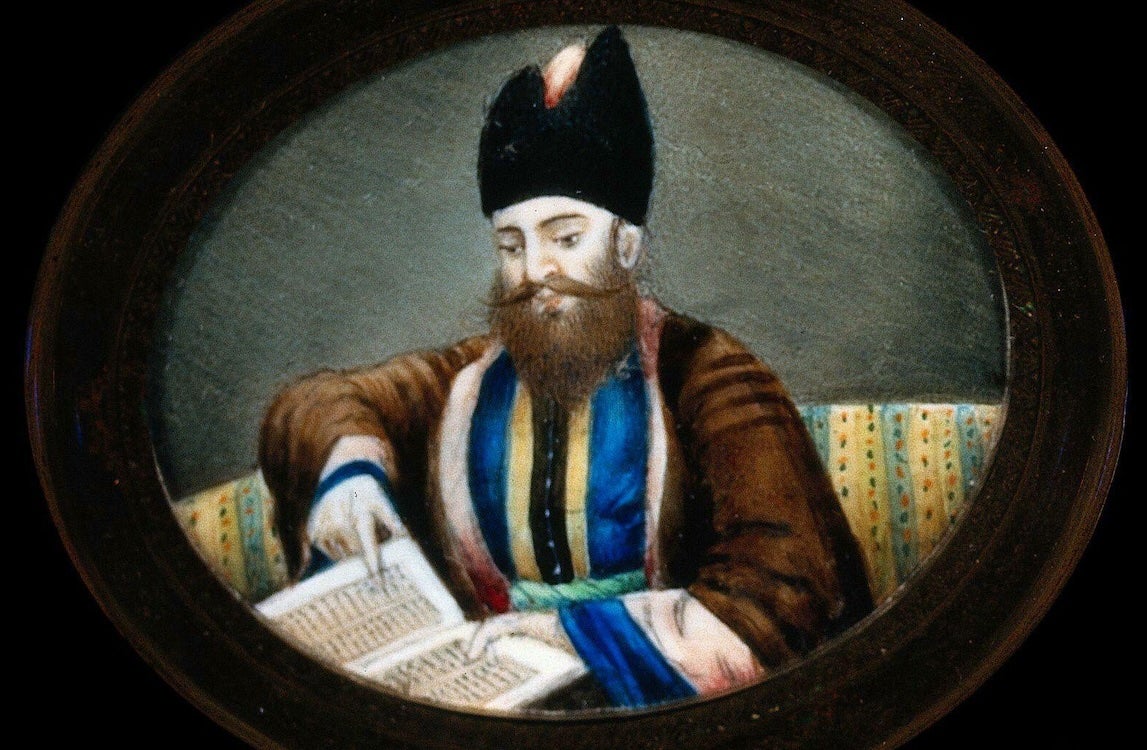 Painting of a bearded man wearing a dark hat and robe, reading and pointing to an open manuscript.