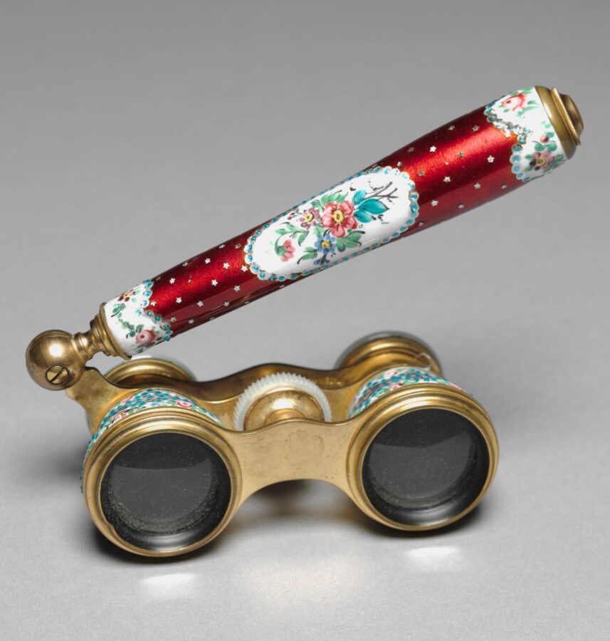 Pair of ornate opera glasses with gold metal casing, red enamel, and hand-painted floral decorations on white panels.