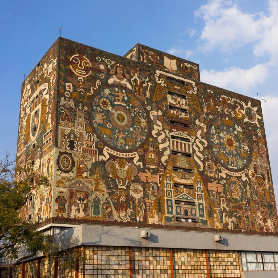 Exterior of the Central Library at the National Autonomous University of Mexico, featuring a large mosaic mural with intricate designs and cultural symbols.